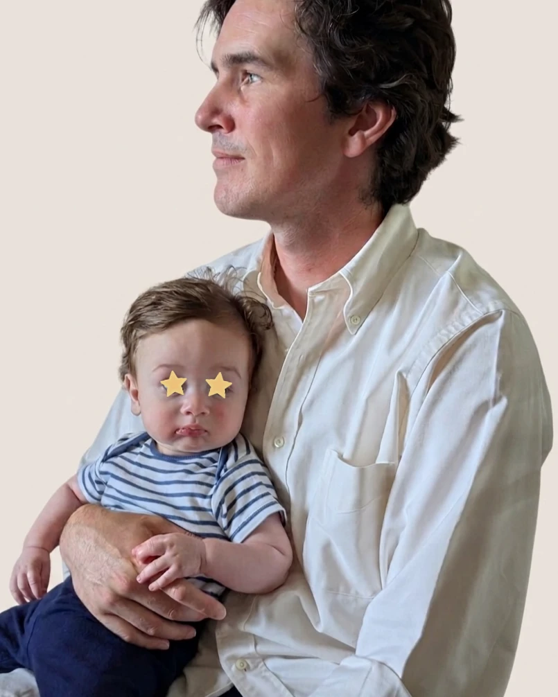 Zach, founder of Fed Enough, holding his baby son on his lap